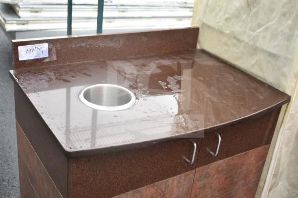 Brown countertop with trash deposit hole, two doors, metal handles, and visible water droplets. Label showing $297.