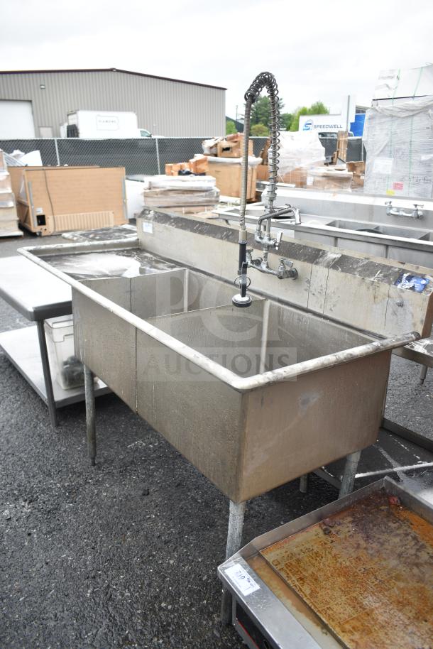 Commercial 2 bay sink with left side drain board, industrial-grade, stainless steel, used condition, suitable for kitchens.