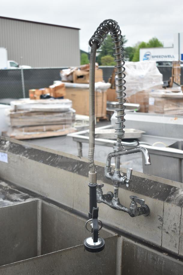 Commercial 2 bay sink with left side drain board, featuring stainless steel construction, attached faucet, and visible wear.