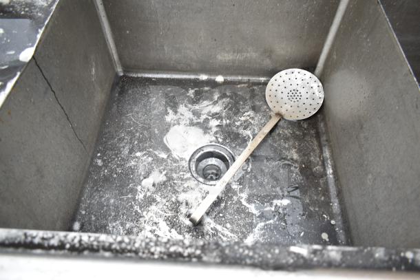 Commercial 2 bay sink with left side drain board, stainless steel, used condition, visible stains and wear.