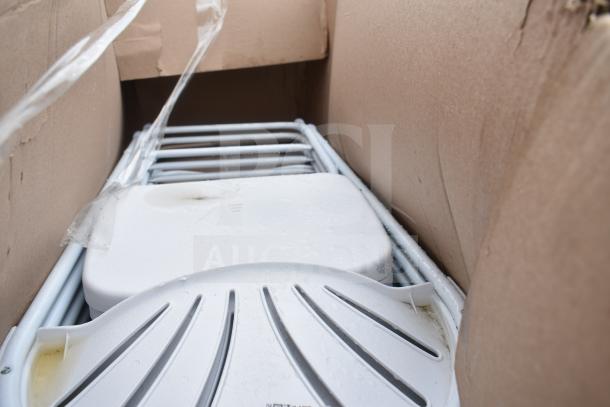 Cardboard box containing 17 brand new, scratch and dent folding chairs. White chairs with visible marks and packaging remnants.