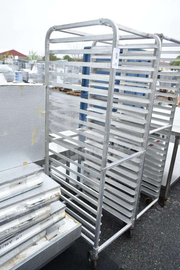 Commercial pan transport rack with multiple shelves, on commercial casters. Metal construction, good condition, tag number 235.