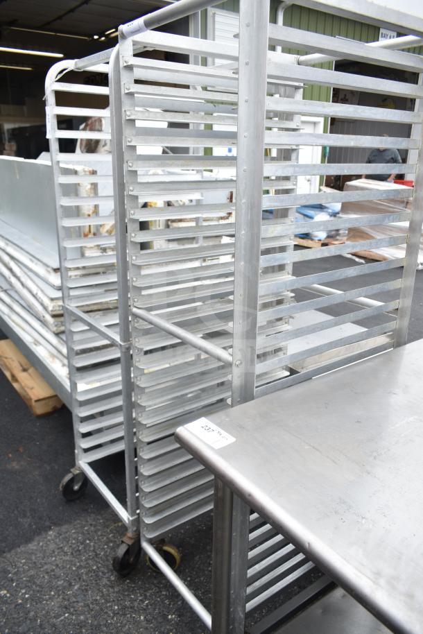 Aluminum commercial pan transport rack with multiple tiers, mounted on commercial casters, in good condition.