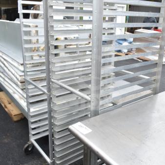Aluminum commercial pan transport rack with multiple tiers, mounted on commercial casters, in good condition.