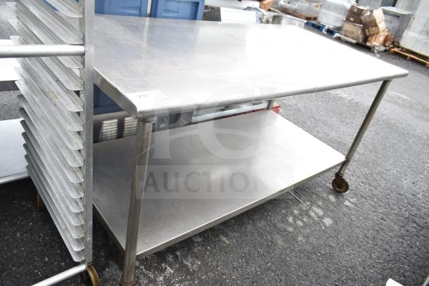 Commercial table with under shelf on casters, stainless steel, used condition, ideal for kitchen or workshop use.