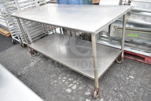 Commercial stainless steel table with under shelf on casters. Features sturdy construction and spacious work surface. Good condition.