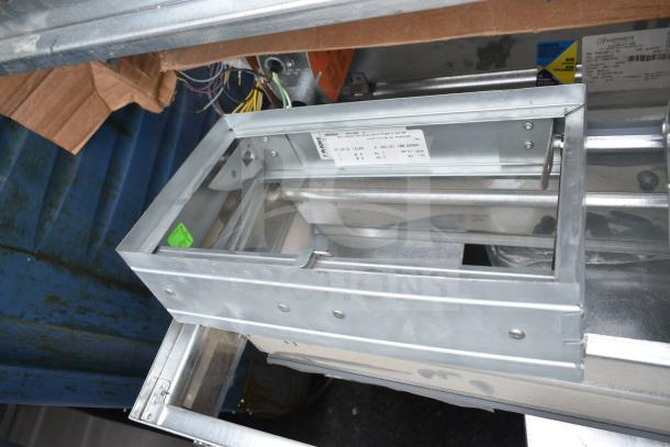 Metallic branch box labeled "BSQ60TVJ," part of a lot with fire damper, Greenheck pieces. Wires visible. Auction of 13 items.