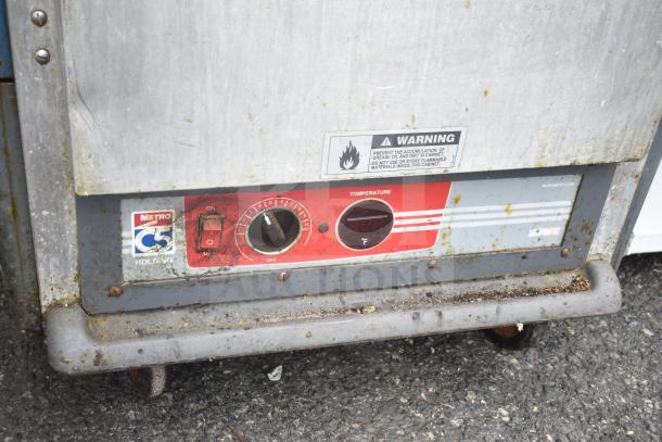 Metro C539-HDS-4-BU heated holding cabinet on casters, 120 volts, 1 phase. Visible dials and warning label. Signs of wear.