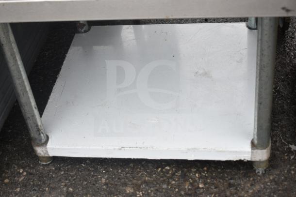 "Regency 600ES3030G equipment stand with under shelf, metal construction, visible surface wear, suitable for heavy appliances."