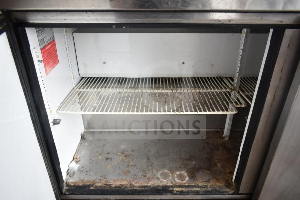 True TWT-60 Commercial 2 Door Work Top Cooler with shelf, visible wear, 115 volts, 1 phase, interior label and warning tag.