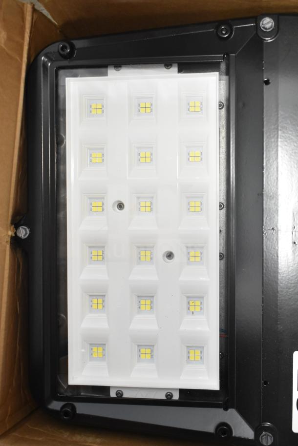 13 Evolve LED Flood Lights in original box, white panel, visible LED grid, new condition, enhance outdoor illumination.