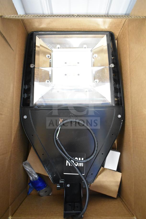 LED flood light in original box, new condition, black finish, GE branding visible. Includes four units.