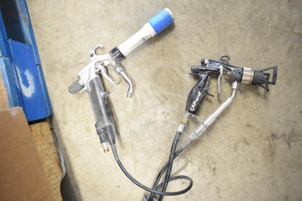 CapSpray compressor/pump with attached spray gun, black and silver finish, visible hoses, used condition, on concrete floor.