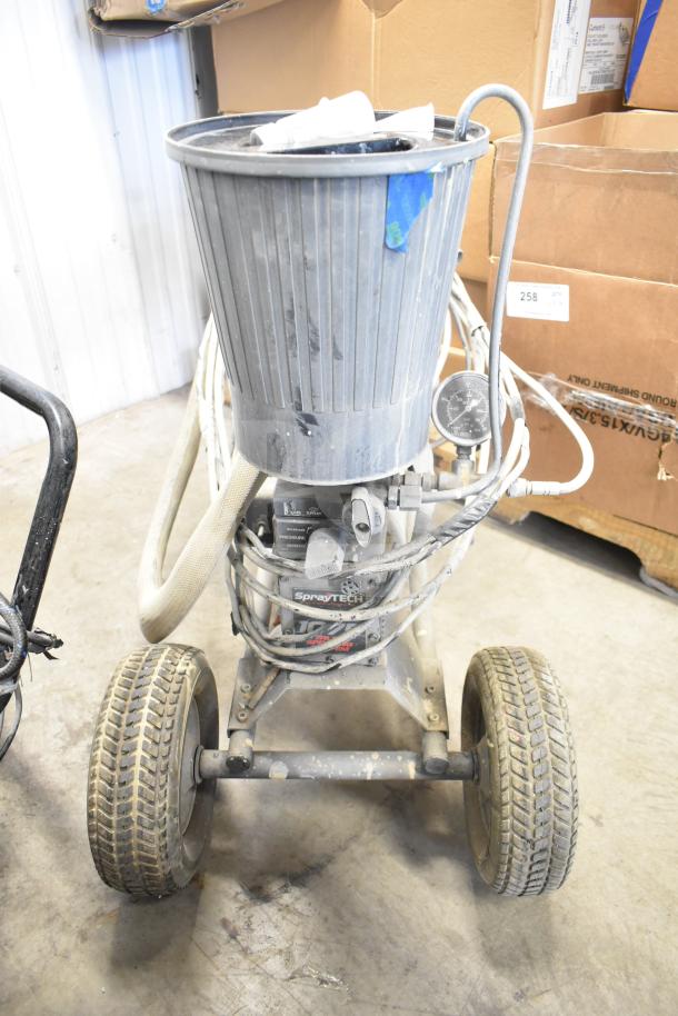 SprayTech 1075 airless spraying system on wheels, showing signs of use, hoses and pressure gauge attached, suitable for large projects.