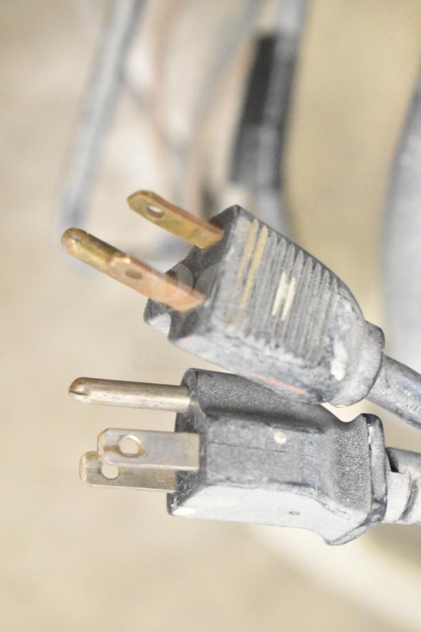 Close-up of SprayTech 1075 Airless Spraying System power plugs, showing slightly worn condition.