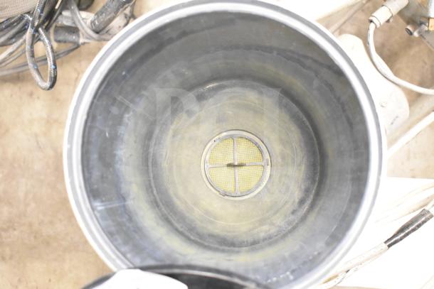 SprayTech 1075 airless spraying system in used condition, featuring a large cylindrical tank with an internal mesh filter.
