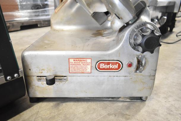 Berkel 818 commercial meat slicer with blade sharpener, 115 volts, used condition, visible warning label and Berkel logo.