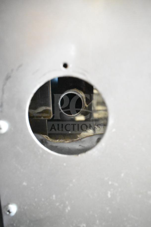 Montague Grizzly 6 burner range, commercial gas, features oven and backsplash. Close-up of a gas pipe connection.