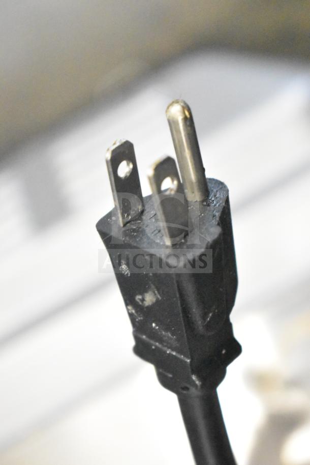Close-up of Waring WCO500X convection oven power plug. Standard 120V, 1 phase, black plug showing slight wear.