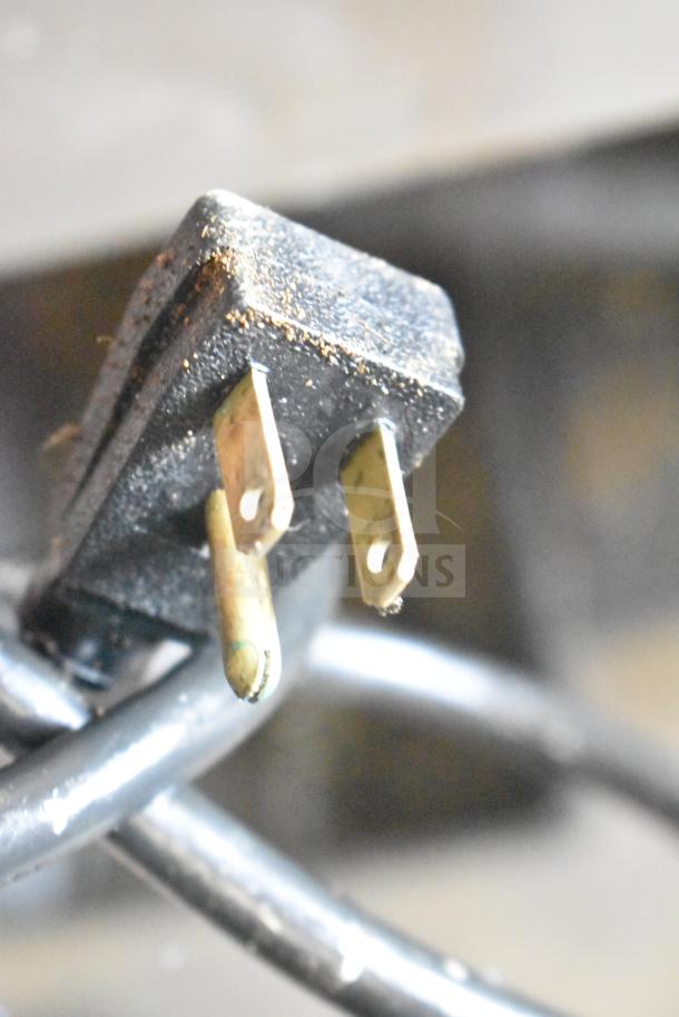 Close-up of a worn electrical plug consistent with 115 volts required for the True T-23 Reach In Cooler.