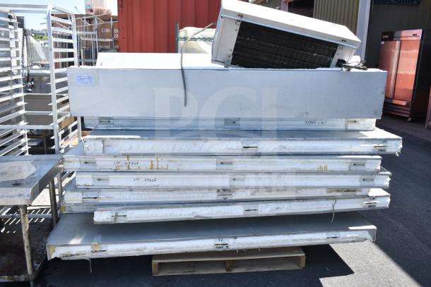 Walk-in box components with evaporator fan, stacked. Visible wear, insulation panels marked with codes. Detached fan unit.