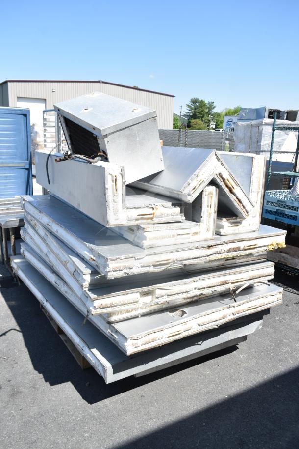 Walk-in box parts with evaporator fan, industrial setting, metal panels, visible wear, outdoor storage.