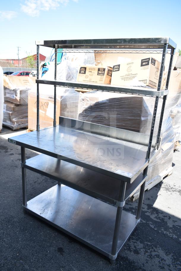 Stainless steel table with 2 under shelves and 2-tier over shelf. Seen outdoors, in good condition. Ideal for kitchen use.