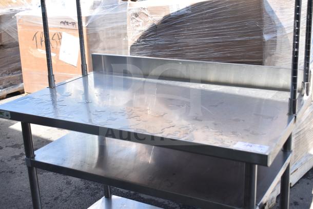 Stainless steel table with two under shelves and two-tier over shelf, visibly clean, suitable for storage and kitchen use.