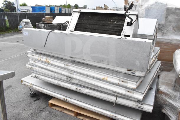 Walk-in box components stacked on a pallet with visible compressor and evaporator fan; no door included.