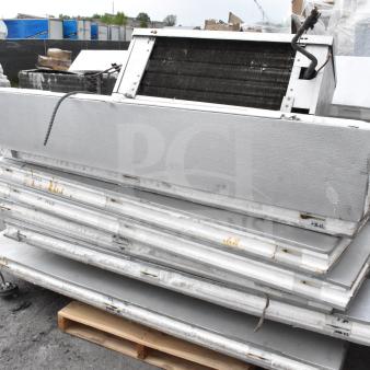Walk-in box components stacked on a pallet with visible compressor and evaporator fan; no door included.