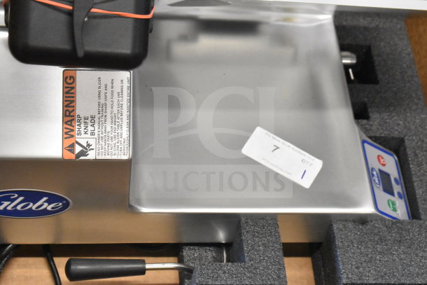 Globe SG13A commercial slicer, new with scratches, features 13" blade and sharpener, labeled warnings, 110V, 1 phase power.