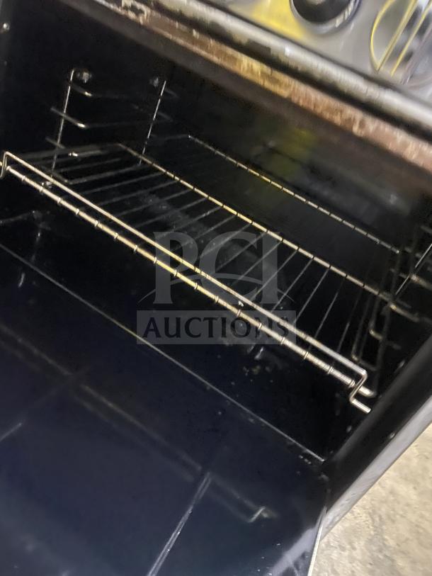 Bakers Pride 60BP10BS26N gas range interior with wire rack, showing stainless steel construction and well-used condition.
