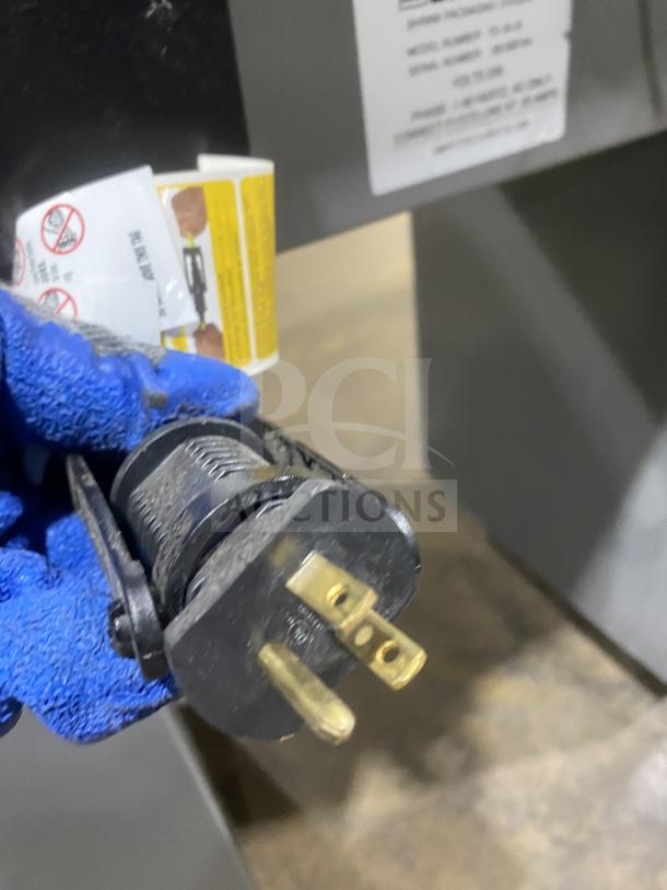 Beseler HS-1520D shrink wrap machine plug with safety labels; model and serial numbers partially visible in background.