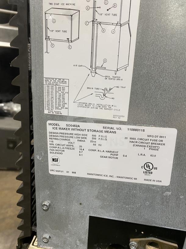 Manitowoc SD0452A stainless steel ice maker/bin combo with lift open access, on legs. Label shows model and specs.