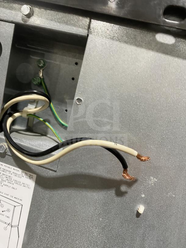 Close-up of wiring inside Manitowoc SD0452A commercial ice machine, showing exposed wires and internal metal components.