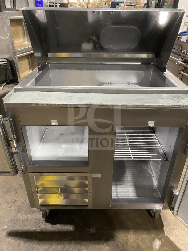 Leader LM36 S/C stainless steel refrigerated sandwich prep table on casters, with hinged top, shelves, 115V 1 phase, good condition.