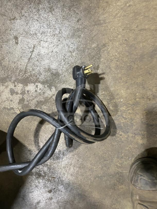 Coiled power cord with standard three-prong plug for So-Low CA5-5 commercial freezer, on concrete floor.