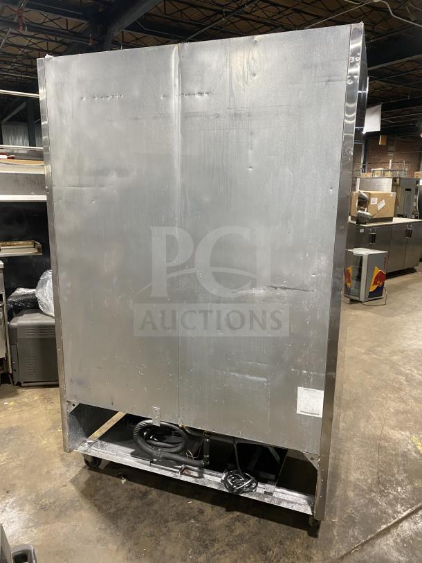 Back view of an Atosa MCF8707 commercial stainless steel double glass swing door refrigerator on casters, showing wiring.