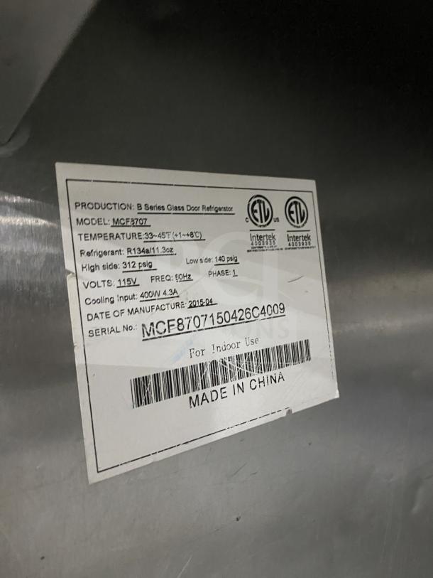 Atosa MCF8707 commercial stainless steel double glass door refrigerator, features poly coated wired rack and casters, model tag visible.