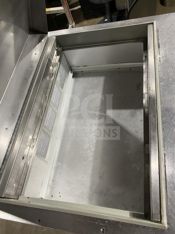 Beverage Air SP27 stainless steel refrigerated sandwich prep table with open storage space, model SP27, on casters.