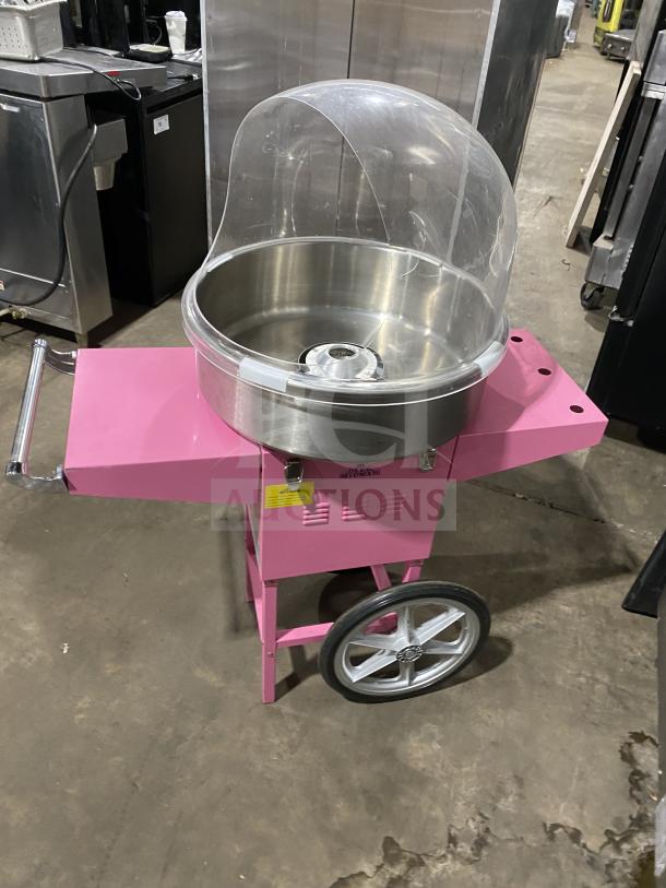 Olde Midway Spin-2000 pink cotton candy machine/cart with a 20" stainless steel bowl and clear dome lid, on wheels.