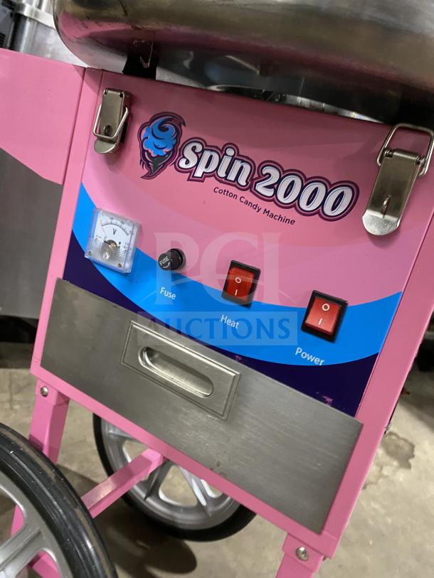 Olde Midway Spin-2000 hot-pink cotton candy machine with stainless steel bowl, clear dome lid, controls, and wheels. Model SN: 5002274.