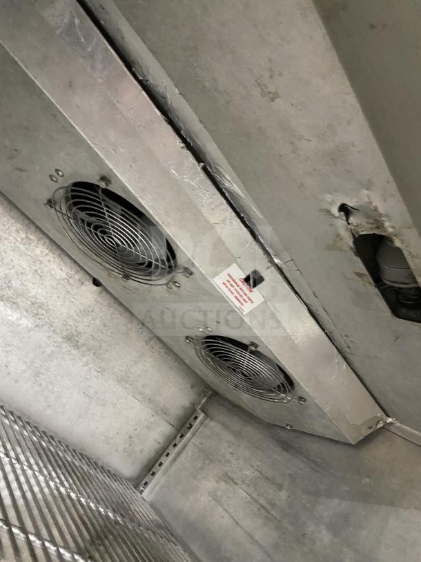 Victory commercial stainless steel roll-in refrigerator interior view. Features ceiling fans and grid shelving. Model for 115V 1 phase.