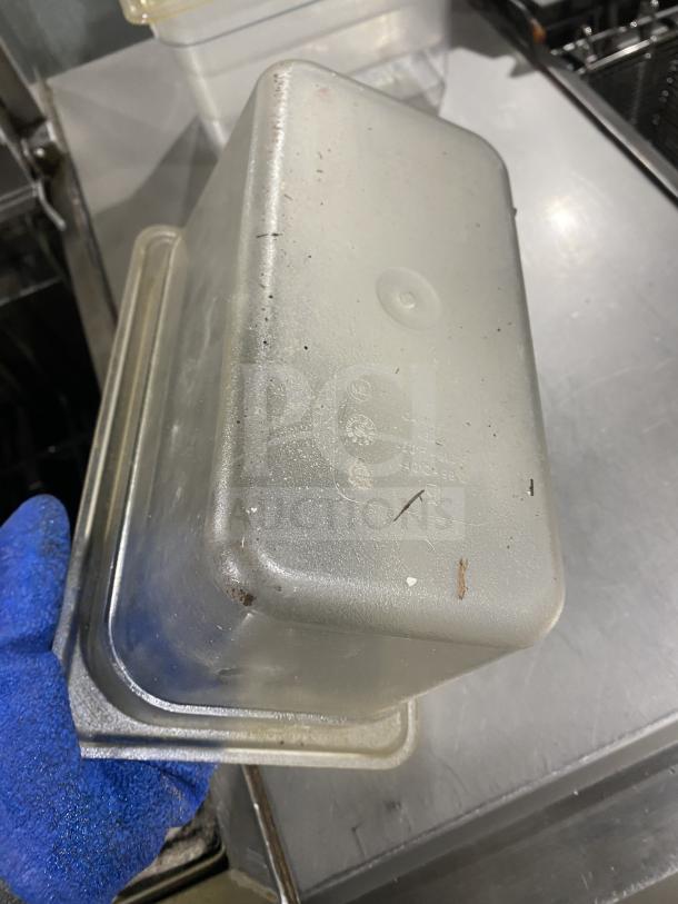 Clear polycarbonate food pan, commercial grade, rectangular shape, used condition, visible recycling markings, gray tones.