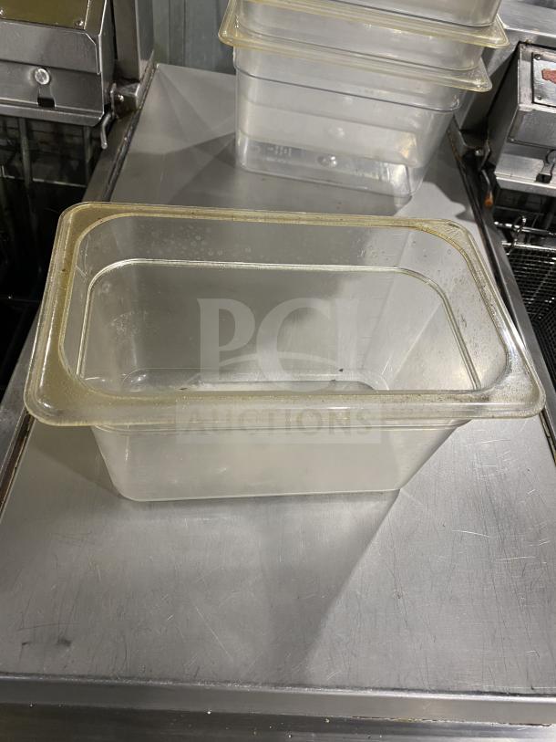 Clear polycarbonate food pan, commercial-grade, rectangular, stackable, with visible rim, used condition.