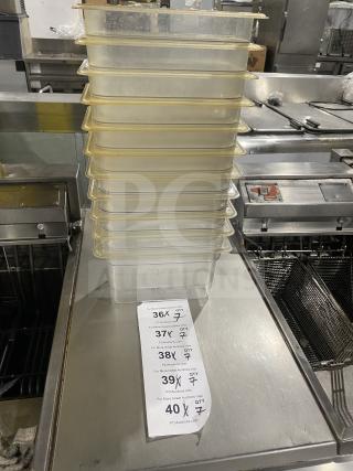 Stack of commercial polycarbonate clear food pans. Each pan is durable and in good condition. Auction tag showing quantities.