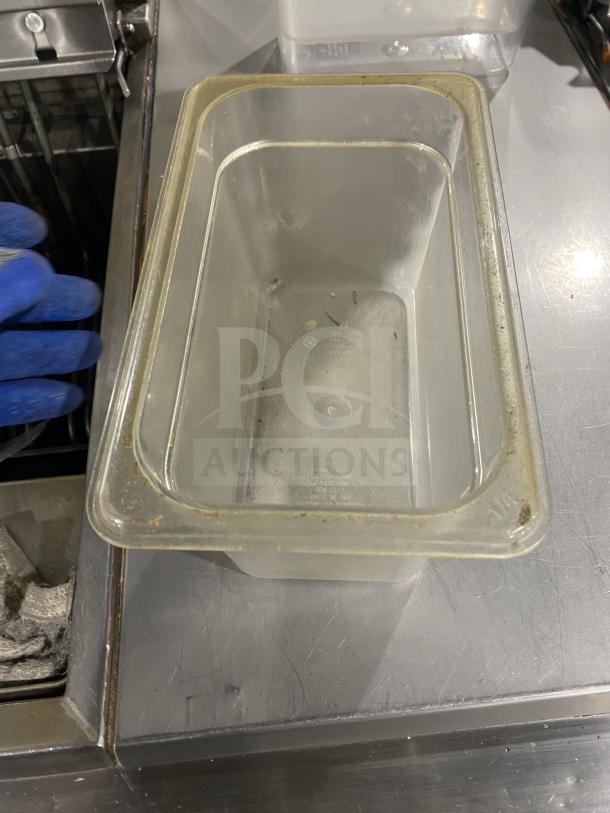 Clear polycarbonate food pan, commercial grade, slightly worn edges, dimensions approximately 7x11 inches, used condition.