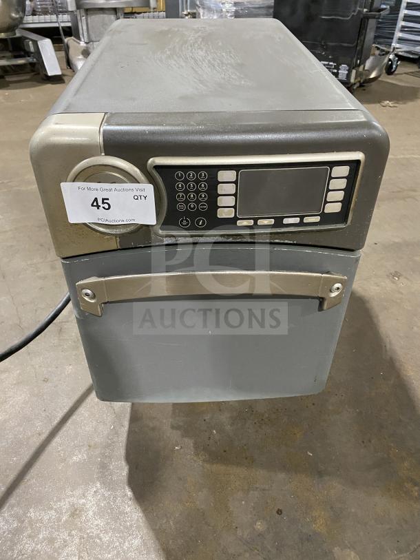 Industrial microwave oven with digital keypad, stainless steel finish. Condition shows wear. Tag indicates auction lot 45.