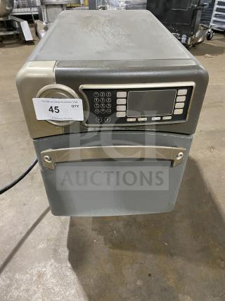 Industrial microwave oven with digital keypad, stainless steel finish. Condition shows wear. Tag indicates auction lot 45.