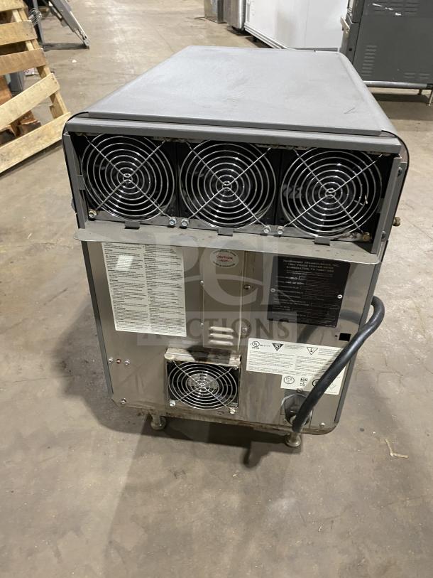Industrial cooling unit with multiple exhaust fans and visible labels. Fair condition, some wear on surface. Power cable attached.